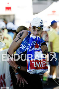 Clemens Coenen slips off wet suit in transition from swim portion of the 2010 Ford Ironman World Championship.