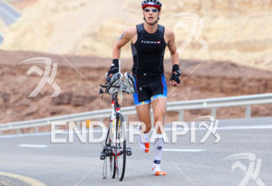 Half distance second Anders Stampe (DEN) running with his bike's chain broken to the transition in the Arava Valley